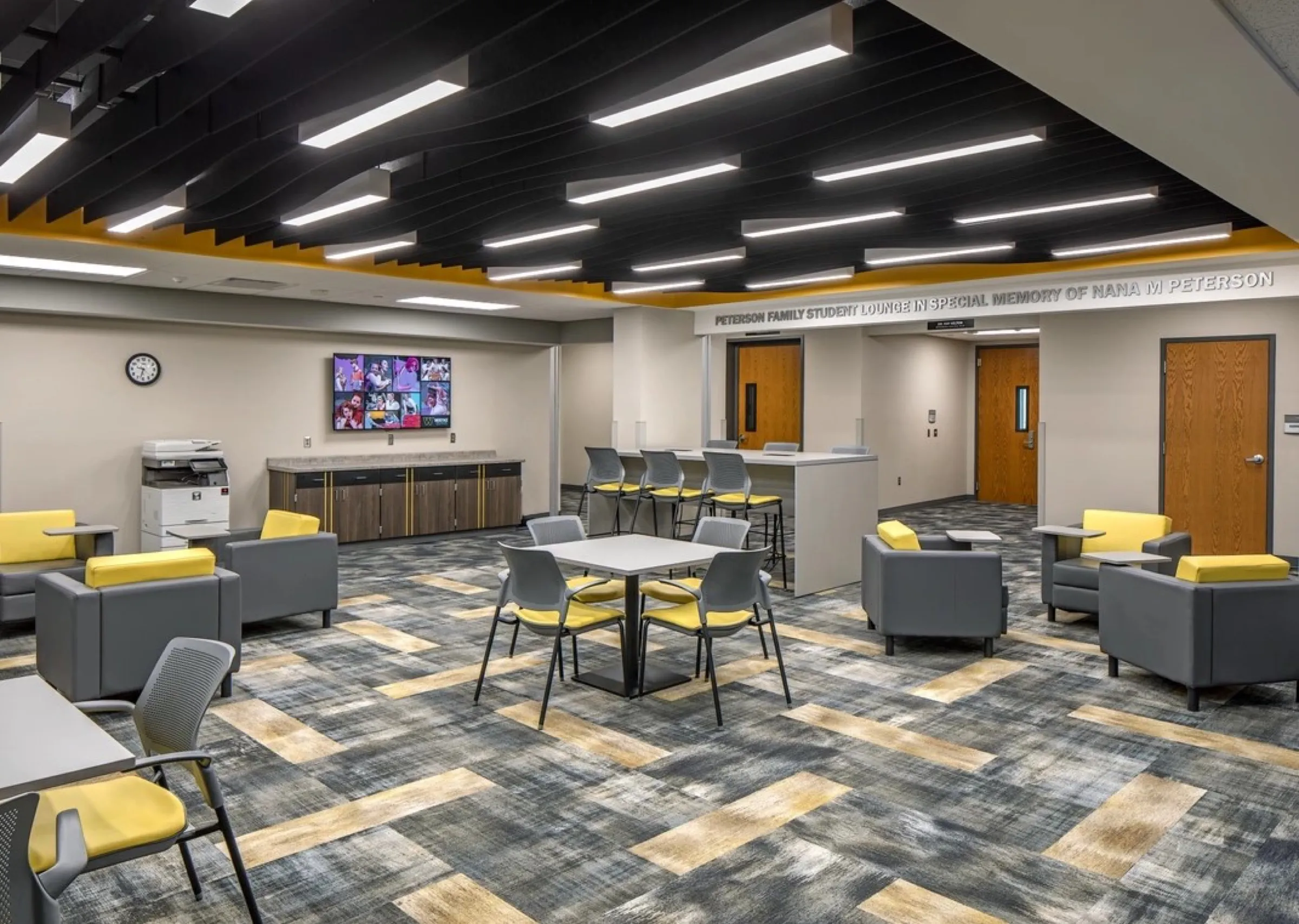Student commons with linear lighting, soft seating and café tables
