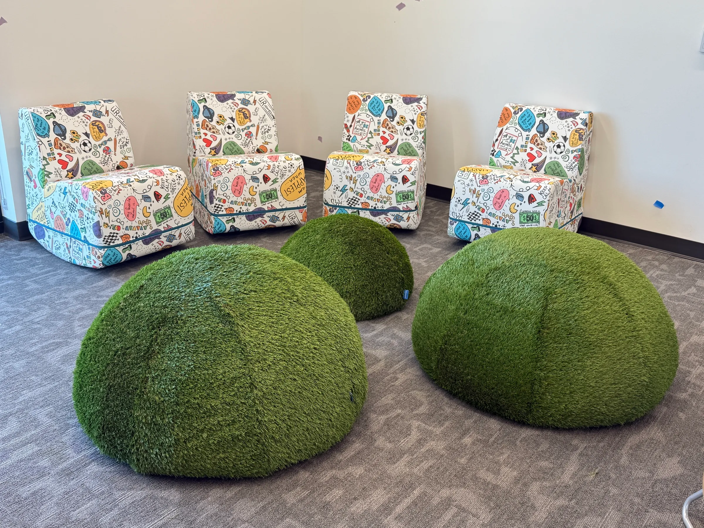 Curved banquette seating beside soft moss-ball floor cushions